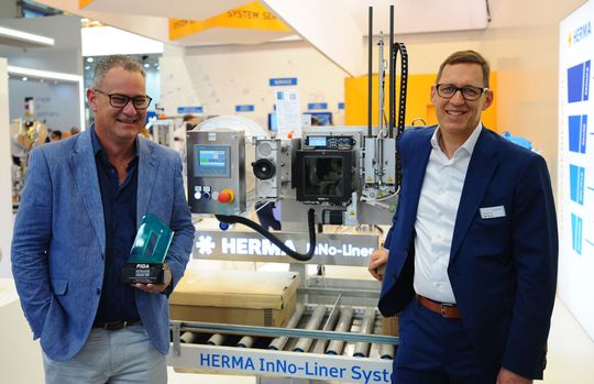 Das Herma-Etikettiersystem Inno-Liner kommt ohne Unterlagenpapier und Silikon aus. Dafür gab es zwei Award-Ehrungen in Australien. Links Michael Dossor, CEO des Vertriebspartners Result Group, bei der Preisübergabe an Martin Kühl, Leiter Herma-Etikettiermaschinen.(Bild:  Herma)