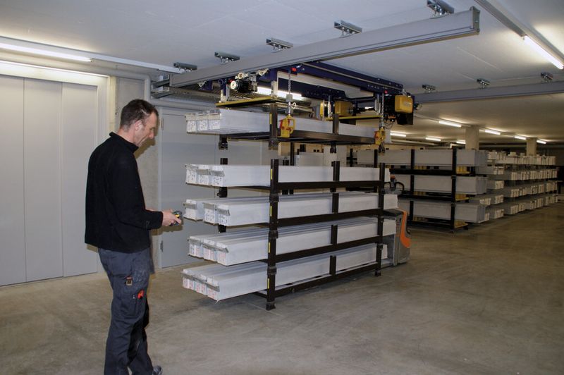 Ein Gestell mit Fensterbänken wird mit der neuen GIS-Krananlage vom Stapel abgehoben. Gut sichtbar ist die Hubbegrenzungmittels Endschaltern. Sie schützen die Anlage auch bei unterschiedlichen Höhen. Dank Funkfernbedienung kann sich die Bedienperson frei und sicher bewegen. (Bild: GIS AG)