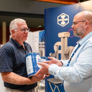 Passender Durstlöscher: Sven Zimmermann (rechts) vom Schraubenspezialisten Ferdinand Gross übergibt Bernd Weinig, Director Trade Fair Solutions & Partnerships bei der Vogel Communications Group ein Fass Schrauben Bräu. (Bild:  Donna und der Blitz)