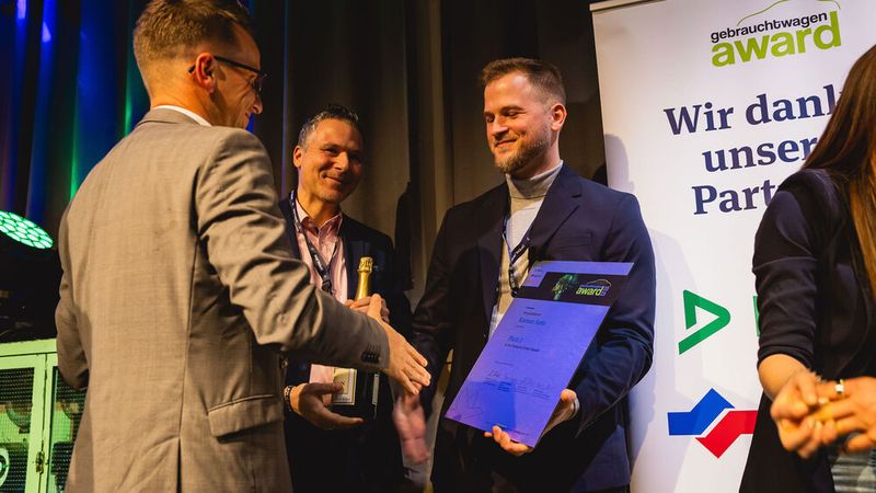 Platz zwei ging an Kamux Auto. Juror Johannes Höfflin gratuliert dem Team. (Bild: stefan bausewein)