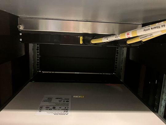 Das Trunk-Aufnahmegehäuse von Rosenberger OSO beitzt eine modulare Rückseite zur anwenderfreundlichen, werkzeuglosen Trunk-Iinstallation, in der Aufnahme direkt unter Arista-Switch. (Bild:  Rosenberger OSI)