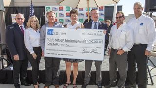 Gene Haas (troisième depuis la gauche) et son épouse (à sa droite) posent avec le chèque de 1million de dollars. (Image: Hass)