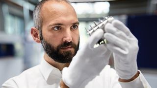 Dr. Thomas Schopphoven, Gruppenleiter Laser Material Deposition am Fraunhofer ILT, prüft ein Metallbauteil. (Fraunhofer ILT/Ralf Baumgarten)