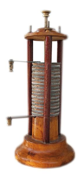 1800 – die Volta’sche Säule: Die Volta’sche Säule oder auch Voltasäule ist eine von Alessandro Volta 1799/1800 entwickelte und im Jahr 1800 an der Royal Society in London der Öffentlichkeit vorgestellte Anordnung, die als Vorläuferin heutiger Batterien im 19. Jahrhundert eine große Bedeutung als Stromquelle hatte. Sie besteht aus vielen übereinander geschichteten Kupfer- und Zinkplättchen, zwischen denen sich in bestimmter regelmäßiger Folge elektrolytgetränkte Papp- oder Lederstücke befinden. Statt Kupfer wurde auch Silber und statt Zink auch Zinn verwendet. Die Voltasäule ist die erste brauchbare kontinuierliche Stromquelle und ermöglichte die Erforschung der Elektrizität – lange vor der Erfindung des elektrischen Generators. Damit hat die Volta’sche Säule der Elektronik und vielen weiteren technischen Bereichen, beispielsweise der Galvanik, den Weg bereitet. Mit Hilfe der Volta’schen Säule bzw. Nachfolgern und damit erzeugten Lichtbögen wurde eine elektrische Beleuchtung mit Bogenlampen realisiert.  (Bild: CC BY-SA 3.0)