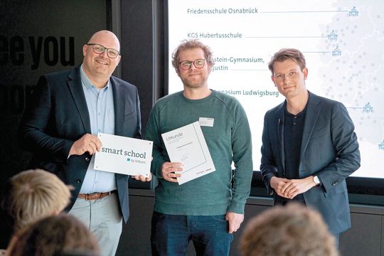 Die Friedensschule Osnabrück wurde als eine von bundesweit acht Schulen zur „Smart School 2025“ gekürt: (v. l.) Schulleiter Christoph Wiebke; Maximilian Knolle, Lernbegleiter & Projektleiter demoKI; Fabian Zacharias, Mitglied der Geschäftsleitung des Bitkom, bei der Preisübergabe. (Bild:  bitkom e.V.)