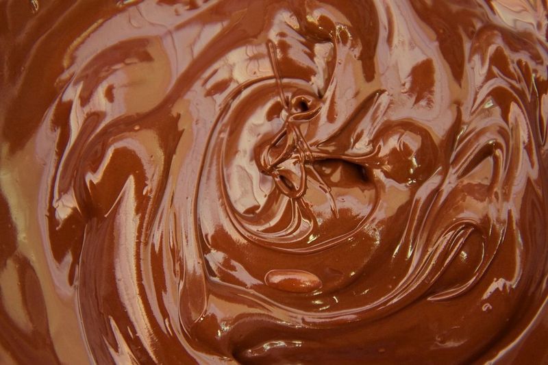 Laut einer britischen Studie senkt der Schokolafenkonsum das Herzinfarkt- und Schlaganfall-Risiko. Grund dafür sei der im Kakao enthaltene Stoff Flavonol, der zellschädigende Stoffe bindet. (Quelle: Public Domain Pictures; CC0 (http://pixabay.com/en/chocolate-melt-milk-brown-food-1934/))