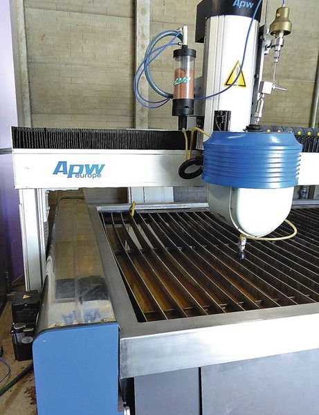 Die essenziellen Elemente der APW-Wasserstrahlschneidmaschine sind die Pumpe (links unten), der 3D-Schneidkopf und oben der Abrasivbehälter. (Bild: Kuhn)