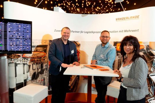 Olaf Schulte (Mitte) von Vanderlande erläuterte die robotergestützte Kommissionierung des Kaufland-Food-Sortiments.(Bild:  Vanderlande)