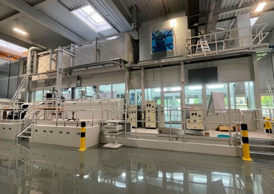 Mit der Erweiterung des Standorts Neuhausen installiert Fanuc eine knapp 30 Meter lange Testanlage für Lackierroboter, mit der ein breites Spektrum an Lacken und Applikationsmethoden unter realen Bedingungen ausprobiert werden können.(Bild:  Fanuc)