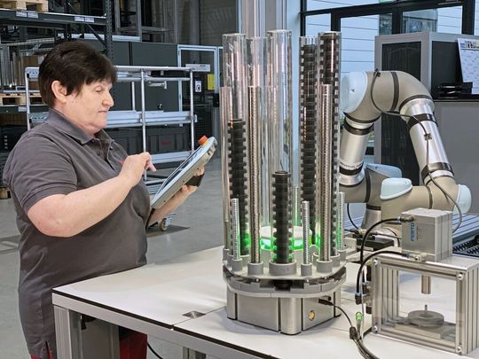 Für die Fertigung der Item-Laufrolle entnimmt der kollaborative Roboter die notwendigen Komponenten und legt sie in die Fügevorrichtung.(Bild:  Item)