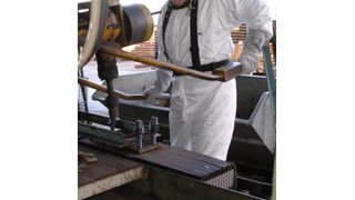 Abb. 1: Beschäftigter im Imprägnierbetrieb bei der Aufplattung von Bahnschwellen. (Bild: BAuA/Uni Erlangen-Nürnberg)