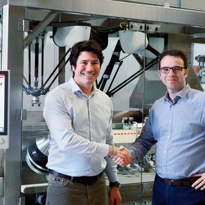Packfeeder-CEO Ferran Martínez (rechts) und Lluís Moreno (links), Sales Engineer von Beckhoff Spanien, vor dem über ein Multitouch-Control-Panel komfortabel bedienbaren Flaschenaufsteller(Bild:  © Packfeeder)