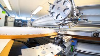 Oberer Nähkopf und Unterfadenstation bilden einen synchronen Verbund in der CNC-gesteuerten Anlage. (sienk.de)