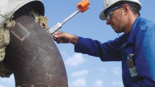 Anbringen eines Hochtemperatur-Sensors Permasense WT210 für die Online-Messung der Wanddicke im Rohrbogen (Emerson Automation Solutions)