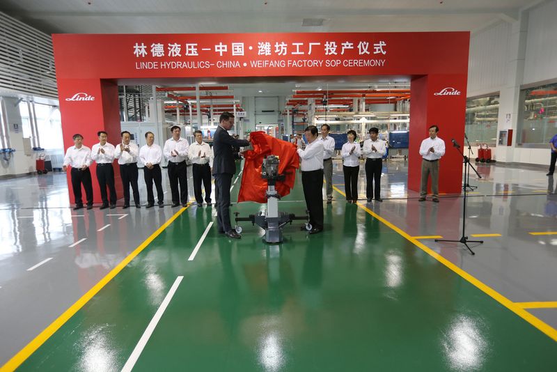 Dr. Jörg Ulrich, CEO, Linde Hydraulics und Tan Xuguang, Chairman Weichai Power (v.l.n.r.) präsentieren die erste komplettierte Produktionseinheit aus dem Werk in Weifang (Bild: Linde)