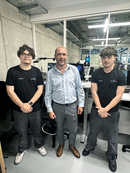 Les deux apprentis de la Monnin Academy entourent Julien Meunier, responsable de production. (Source : Margaux Pontieu)