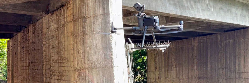 Drohnen fliegen in festgelegten Routen um Brücken und fotografieren sie ab.