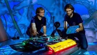 Zwei Freiberger Informatiker an dem neu entwickelten Schwimmroboter „Elisabeth“ in der CAVE. (Detlev Müller / TU Bergakademie Freiberg)