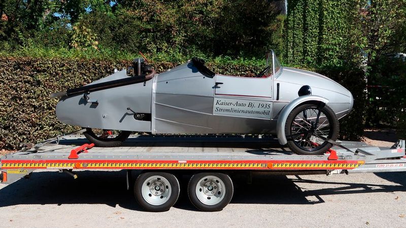Die Sicherung einer solchen Preziose auf dem Transportanhänger ist diffizil. Trapezgurte würden die Speichenräder verformen, Dreipunktgurte auf den schmalen Reifenlaufflächen keinen Halt finden. Das Fixieren der Karosserie kommt ebenfalls nicht in Frage. Noch besser als die gewählte Lösung wären zwei Einzelgurte vorn, befestigt an den Radaufhängungen, und ein Anhänger mit geschlossenem Aufbau. Der hintere Radanschlag wird seiner Funktion an dieser Kontaktstelle nicht gerecht. (Bild: Peter Diehl)
