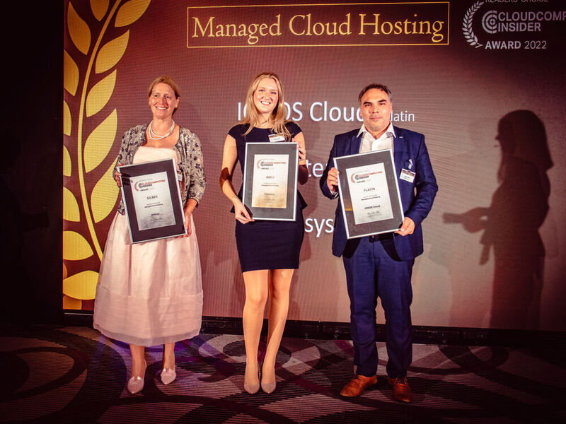 Die Preise für ausgezeichnetes „Managed Cloud Hosting“ nehmen Claudio Serrano (rechts) für IONOS Cloud (Platin) und Andrea Hendrickx (links) für Infosys (Silber) persönlich entgegen. Award-Fee Luca hält den Gold-Award für T-Systems in die Kamera. (Bild: krassevideos.de)
