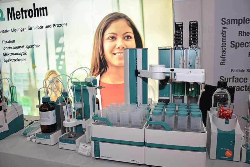 Autotitrator mit Probensampler: Der Omnis von Metrohm ist ein Titrationsroboter, der mit einem Probensampler ausgestattet werden kann. Ein greifarm nimmt sich dann die Proben und verschließt diese nach Entnahme wieder mit einem Deckel. (LABORPRAXIS, C. Lüttmann)