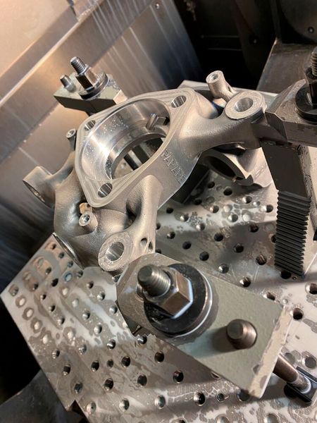 Noch etwas benetzt von Kühlschmiermittel, sieht man hier einen der besonderen Golf-Achsschenkel im Arbeitsbereich einer CNC-Fräsmaschine bei Parare fixiert. (Bild: Parare)