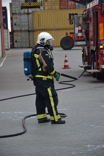 während ein weiterer Kollege sich mit einem Löschschlauch im Hintergrund bereithält. (PROCESS)