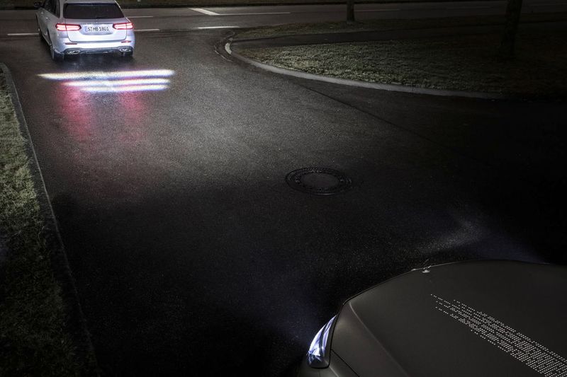 Wird über die Radarsensoren erkannt, dass der Sicherheitsabstand zum vorausfahrenden Fahrzeug zu gering ist, kann der Scheinwerfer einen Warnhinweis auf die Straße zeichnen. (Daimler)