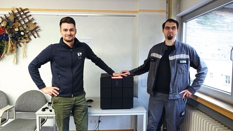 Marc Stegmaier (l.), Sven Groß und ihr neuester „Mitarbeiter“, der 3D-Drucker von Schubert: Er wird bereits operativ zur Ersatzteilfertigung eingesetzt.