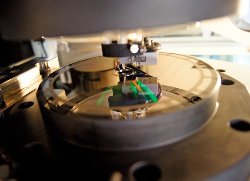 Bild 5: Beim Aufbringen der zweiten Informationsebene in der sogenannten Wet-Embossing-Phase kommt ein Rundschalttisch zum Einsatz, der über eine Hub-Schwenkachse das Drehen und Anheben der Discs übernimmt. (Bild: Singulus)