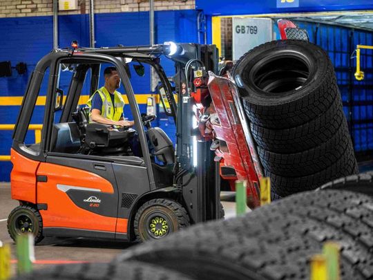 Der Transport der großen Nutzfahrzeugreifen erfolgt per drehbarer Reifenklammer – und erfordert von den Beschäftigten in der Logistik höchste Konzentration.(Bild:  Linde MH)