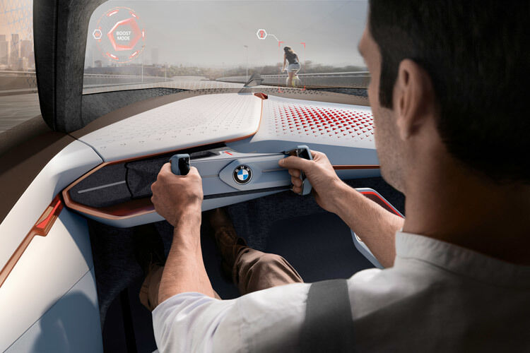 Bedient wird der BMW vor allem durch Gestensteuerung in der Luft, alle Informationen werden auf der Windschutzscheibe angezeigt. Mit Augmented-Reality-Technik zeichnet der BMW beispielsweise die Ideallinie und das empfohlene Tempo auf die Straße und zeigt dem Fahrer Hindernisse an, die er noch gar nicht sehen kann. (Foto: BMW)