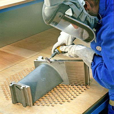 Trotz moderner Bearbeitungsmaschinen für das Schleifen, Fräsen und Erodieren müssen alle bearbeiteten Kanten der Turbinenschaufel von Fachkräften manuell entgratet werden. (Archiv: Vogel Business Media)