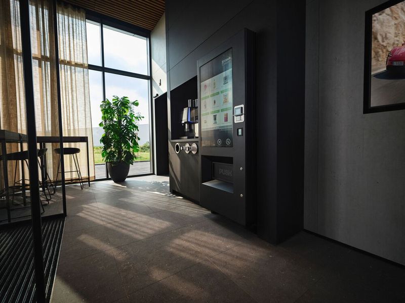 In der Lounge gibt es Toiletten, WLAN, Automaten für Kaffee, kalte Getränke sowie Snacks aus der Region. Auch wenn Rhein und Nahe nur einen Steinwurf entfernt sind, Wein gibt es keinen in der Selbstbedienungslounge, die rund um die Uhr geöffnet hat. Allerdings gilt: Porsche only! Anders als Audi, die Fremdmarken an ihre Charging Hubs zulassen, erhalten in Bingen nur Porsche-Fahrer Zugang zum Gelände sowie zur Lounge.  (Bild: Porsche)