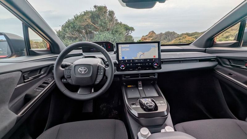Blick in den aufgeräumten Innenraum und auf das fahrerorientierte Cockpit. Das Raumgefühl ist luftig, die Qualitätsanmutung ordentlich. Komplett verzichtet hat Toyota nicht auf Drehregler und Tasten. Das kommt der Bedienung zugute, wobei das Lenkrad etwas mit Bedienelementen überfrachtet ist. Statt Head-up-Display setzt der Hersteller auf ein 7 Zoll großes Fahrerinformationsdisplay über dem Lenkrad. Es ist direkt an der Frontscheibe platziert. Je nach Sitzposition schränkt das Lenkrad die Sicht etwas ein. Ein Eyecatcher ist das 14 Zoll große Multimediadisplay in der Mittelkonsole. (Bild: Mauritz – VCG)