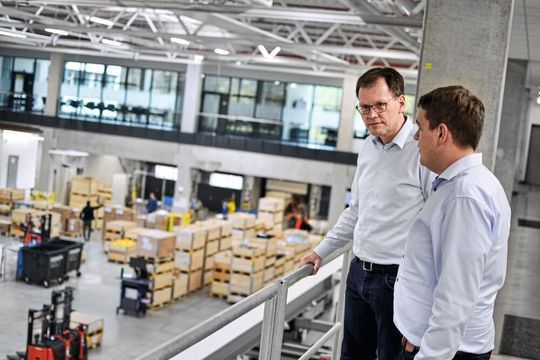 Lenze-Hochregallager werden jetzt per KI-Assistent gewartet, um kommende Probleme zu erkennen, bevor sie akut werden. Links: Dr. Heiko Stichweh, Abteilungsleiter Innovation bei Lenze, der das Ganze mit Maximilian Bause (rechts) vom Fraunhofer-IEM entwickelt hat.(Bild:  Dock One)