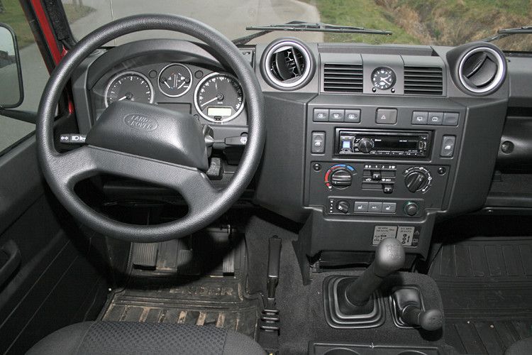 Das Zündschloss befindet sich links und ist schlecht erreichbar, da der ganze Arbeitsplatz, wie bereits gesagt, recht nah an die Tür gerückt ist. Die Handbremse liegt links des Mitteltunnels, um neben den Hebeln für die Schaltung und das Untersetzungsgetriebe auch Platz für Cupholder und ein Staufach nebst Armauflage zu lassen. (Foto: auto-medienportal.net)