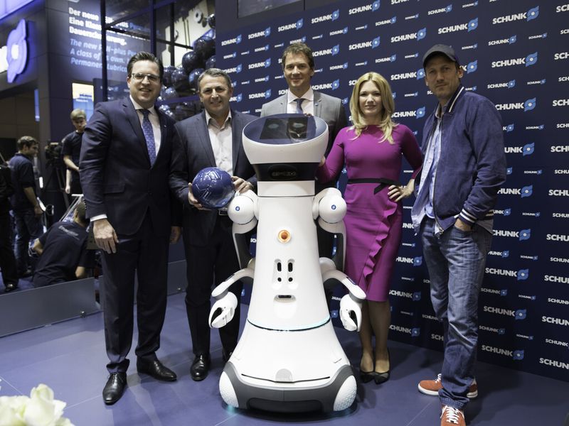 Smart Excellence: Der Serviceroboter Care-O-bot 4 zusammen mit dem geschäftsführenden Gesellschafter Henrik A. Schunk, VfL-Geschäftsführer Klaus Allofs, Schunk-Markenbotschafter Jens Lehmann, Sky Moderatorin Jessica Kastrop und Schauspieler Wotan Wilke Möhring (v.l.n.r.). (Bild: Schunk)