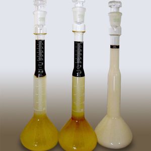 Emulsionsstabilität/Salzsäurespaltung: 100 ml Emulsion wurden mit 30 ml konzentrierter Salzsäure versetzt. Von links nach rechts zwei Grobziehmittel von Wettbewerbern und Multidraw CU UNI S, das sich unter gleichen Bedingungen deutlich schwerer spalten lässt.