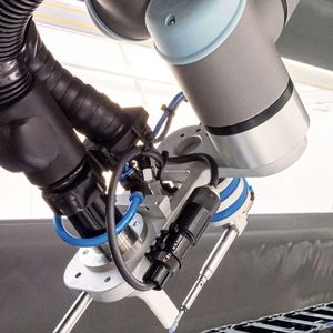 Eine Adaptereinheit verbindet am Roboterkopf Schleifspindel, Absaugung und Ionisator, welcher die elektrostatische Aufladung des Materials schnell und auf großer Entfernung neutralisiert. (Bild:  SEW-Eurodrive)