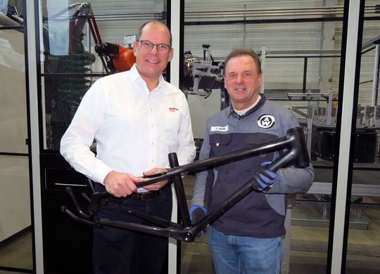Felix Dorn of Weber Fibertech, right, and Joachim Scheffer of Oerlikon HRS Flow, presenting a frame for the li:on youth bicycle that was injection-molded using water injection technology and Flexflow HRS servo-driven hot runner technology. (Source:  Oerlikon HRS Flow)
