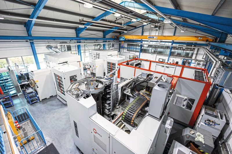 Auf den beiden C 22 U (im Hintergrund) bearbeitet TVB ausschließlich Grafit. Der Roboter belädt die C 32 U (vorn rechts) mit Aluminium- und Messing-Bauteilen. (Bild: Hermle)