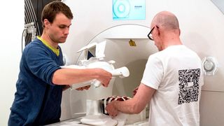 Die Mitarbeiter von Preisträger Jens Frahm, Volkert Roeloffs (l) und Kurt Böhm, legen eine Kopfspule, mit der sie Gewebeeigenschaften simulieren, in ein Magnetresonanztomograph (MRT). Frahm ist am 07.06.2018 in Paris mit dem Europäischen Erfinderpreis ausgezeichnet worden.  (Swen Pförtner/dpa)