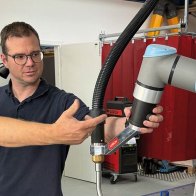WEMAG-Geschäftsführer Christopher Schaus präsentiert einen Cobot (Quelle: WEMAG GmbH & Co. KG)