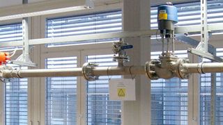 Hydraulikprüfstand zur Effizienzmessung nach ISO 9906. Das spezielle Beruhigungsgefäß rechts im Bild ist Voraussetzung für eine gleichmäßige Strömung und ermöglicht zudem die Erwärmung der Flüssigkeit, in der Regel Wasser. (© David Reiff, Dr. Volker Staudt)