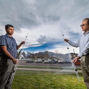Eldho Abraham, left, and Taewoo Lee, right, hold up a new window insulation material called Mochi-affixed to a thin sheet of plastic, which was designed by CU Boulder researchers in physic professor Ivan Smalyukh’s lab. (Source:  Glenn J. Asakawa/CU Boulder)