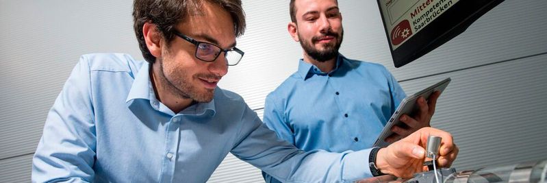 Steffen Klein (l.) und Christopher Schnur aus dem Team von Professor Andreas Schütze forschen an dem neuen Wartungssystem, das Sensoren an Industrieanlagen smart macht.(Bild:  Oliver Dietze)