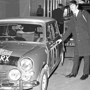 Beatle-Schlagzeuger Ringo Starr posiert bei seiner Ankunft auf dem Pariser Flughafen Le Bourget am 15. Januar 1964 mit dem BMC-Mini, der an der bevorstehenden Rallye Monte Carlo teilnehmen wird.(Bild:  picture alliance / AP)