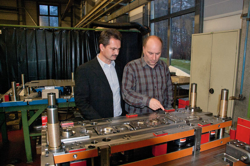 Thomas Schumacher (links), einer der drei Kunrath-Geschäftsführer, zusammen mit Prokurist Marco Schorr hinter der Unterseite eines vierstufigen Folgeverbundwerkzeugs: „VISI ist im Werkzeugbereich extrem produktiv.“ (Bild: Mecadat)