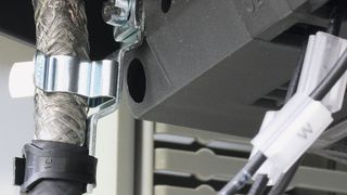 Schirmklammern: Sie dienen zur Verbindung von außenliegenden Leitungsschirmen mit dem Massepotential (z.B. bei Koax-Kabeln), um die elektromagnetische Verträglichkeit zu gewährleisten. Das Bild zeigt die Anwendung Frequenzumrichter, der in einem Schaltschrank verbaut ist.  (icotek)